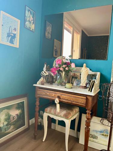 奥登河畔的布雷特维尔Chez Toinette的一间房间,桌子上放着花瓶