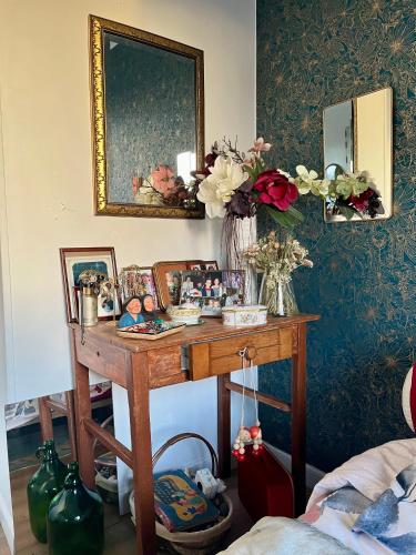 奥登河畔的布雷特维尔Chez Toinette的配有鲜花和镜子的桌子的房间
