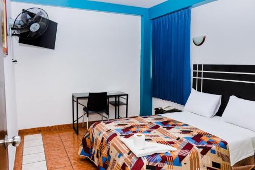 齐克拉约Zentrico Hotel的一间卧室配有一张床、一张桌子和一张书桌