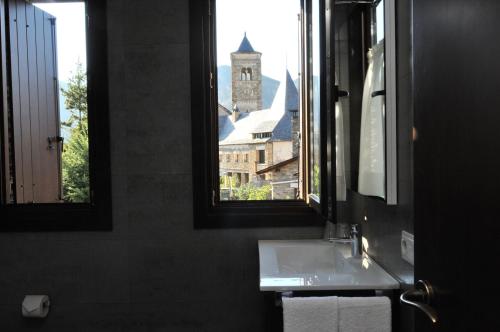 Tirvia卡萨拉柯美拉乡村酒店的一间带水槽的浴室和一个带钟楼窗户