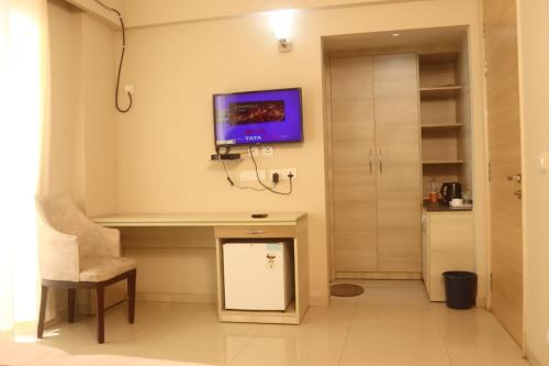 马图拉Hotel Shyam Basera的客房设有书桌和墙上的电视。