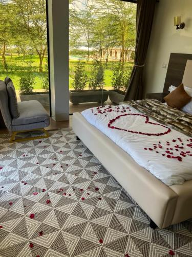 GilgilLake Elementaita Manor的卧室配有一张玫瑰花瓣床,位于地板上