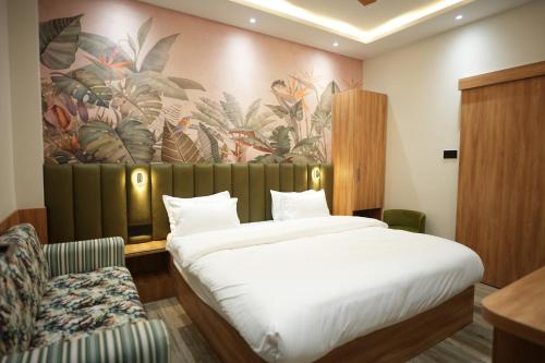 戈勒克布尔Ashoka Hotel的一间卧室配有一张大床和一把椅子