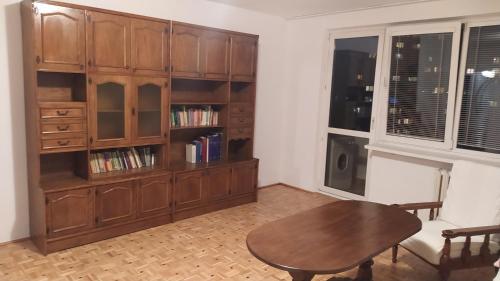 华沙Uroczy apartament z bezpłatnych parkingiem的客厅配有桌子和书架