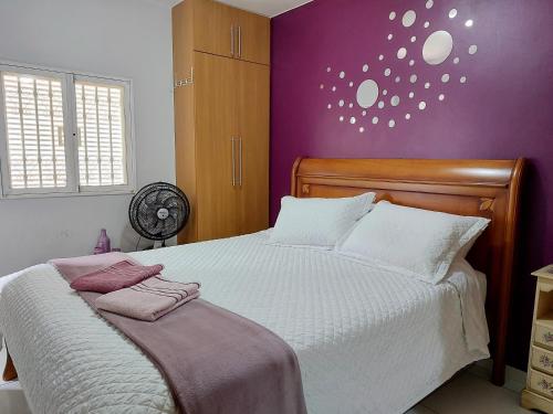巴西利亚Ideal para família e grupos, local nota 10 e Wi-fi top!的一间卧室设有一张紫色墙壁的大床