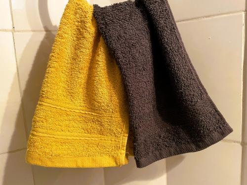 莫希Home Feeling Neneu Lodge的浴室墙上挂着一条黄色毛巾