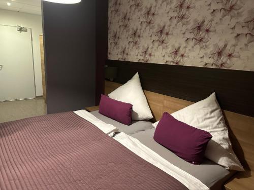 VecheldeHotel Efcannos Dornberg Carree的一间卧室配有一张带紫色和白色枕头的床