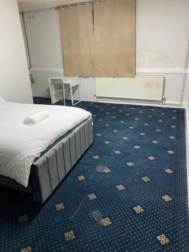 奥尔德姆Cozy spacious double room rm 8的一间卧室配有一张床,铺有蓝色地板