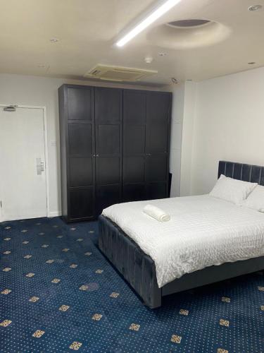 奥尔德姆Cozy spacious double room rm 8的一间卧室配有一张床和一个黑色橱柜