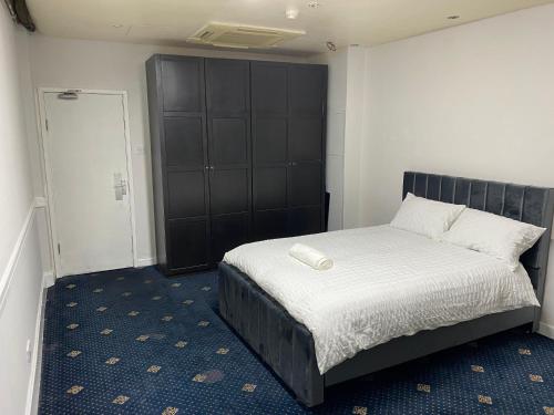 奥尔德姆Cozy spacious double room rm 8的一间卧室配有一张带黑色床头板的床