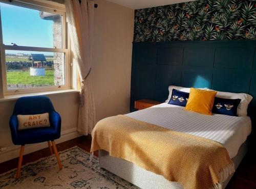 杜林Cliffs View Self Catering @ Limestone Lodge的卧室配有床、椅子和窗户。