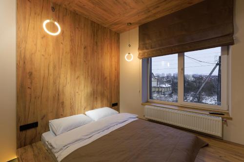 赫梅利尼茨基Discovery Garden apartments的一间卧室设有一张大床和一个窗户。