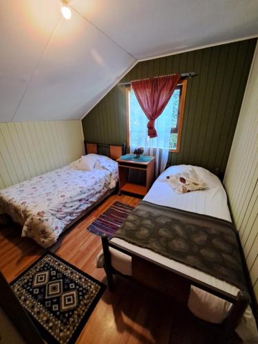 延基韦Cabaña puerto varas的一间卧室设有两张床和窗户。
