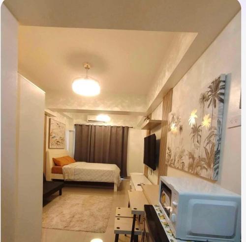 马尼拉Condotel-Shore 2 Residences MOA的小房间设有床铺和电视