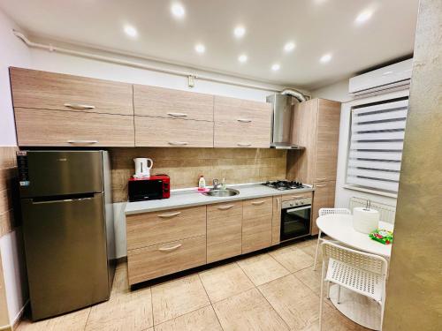 Popeşti-LeordeniConfort City Residence的厨房配有木制橱柜和不锈钢冰箱。