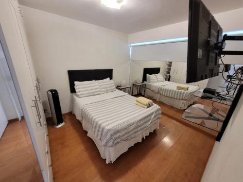 利马Espacio Luxury Apartments - Calle Independencia, Miraflores的一间卧室配有两张床和一台平面电视