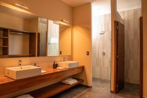 埃斯孔迪多港Casa Amelia Puerto Escondido的一间带两个盥洗盆和淋浴的浴室