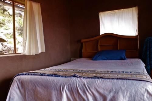 HuillanopampaWHITE SAND Taquile Lodge的一间卧室设有一张大床和窗户