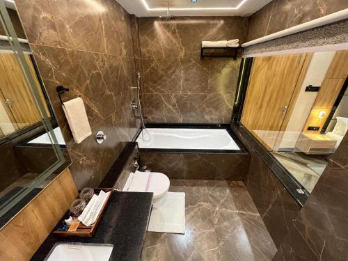 戈勒克布尔Ashoka Hotel的带浴缸、卫生间和盥洗盆的浴室