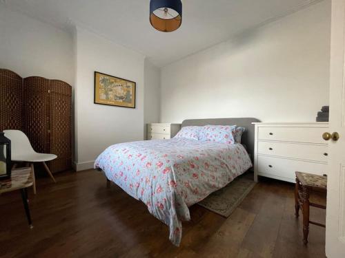 滨海绍森德Stylish, Modern & refurbished flat, 1.5m beach的一间卧室配有一张床、梳妆台和椅子