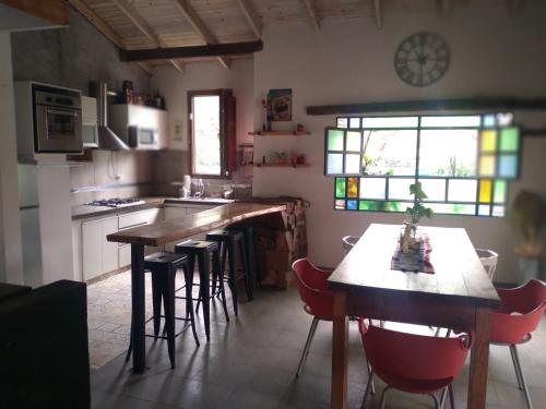 San RoqueCASONA PINTORESCA en las sierras的厨房配有木桌和椅子,设有窗户。