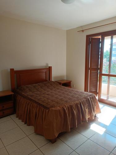 圣玛丽亚Apto grande em Camobi的一间卧室设有一张床和一个大窗户