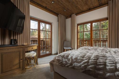 锡纳亚Chalet Royal的卧室配有一张床、一张书桌和窗户。