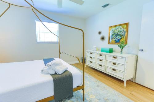 克利尔沃特Magnolia Home • Clearwater Beach • BBQ • Sunroom的一间白色卧室,配有一张床和一个梳妆台