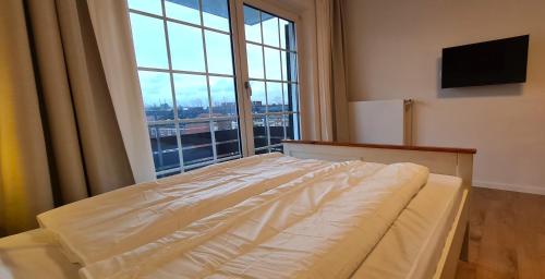 杜塞尔多夫Renoviertes Apartment inkl TG Stellplatz in Düsseldorf的一张位于带大窗户的房间内的床铺