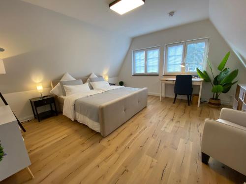 不莱梅Stadtoase: Exklusive Apartments für Ruhe und Entspannung的一间大卧室,配有一张床和一张书桌