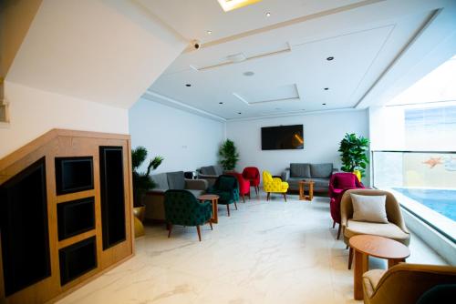 丹吉尔Twin Hotel Tanger的一间设有五颜六色的椅子和桌子的等候室