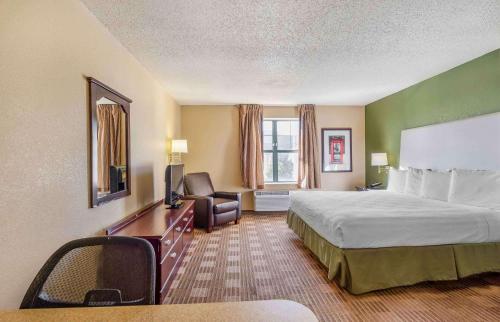 唐纳斯格罗夫Extended Stay America Select Suites - Chicago - Downers Grove的酒店客房设有一张大床和一张书桌。