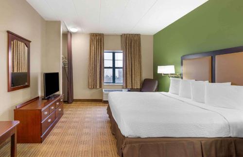 莱尔Extended Stay America Select Suites - Chicago - Lisle的酒店客房设有一张大床和一台电视。