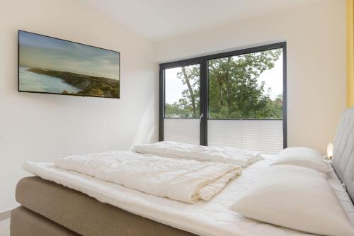 朱列斯拉赫Residenz Mare Baltikum FeWo 3 - strandnah, Terrasse, Sauna的白色卧室设有一张大床和两个窗户