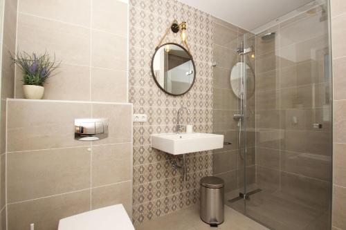奥斯特巴德·哥伦strandnahes Haus mit Meerblick, gratis Nutzung vom AHOI Erlebnisbad und Sauna in Sellin - Sealodge Rügen的带淋浴、盥洗盆和镜子的浴室