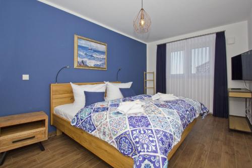 布雷格Ferienhaus Luna Haus - Terrasse, Garten, Sauna的一间卧室配有一张蓝色墙壁的床