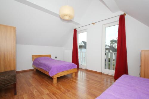 格洛韦Ferienhaus Wellenläufer Haus - Sauna, Terrasse, Garten的一间卧室设有紫色的床和窗户