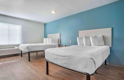 拜勒姆Extended Stay America Select Suites - Jackson - South的一间卧室设有两张床和蓝色的墙壁