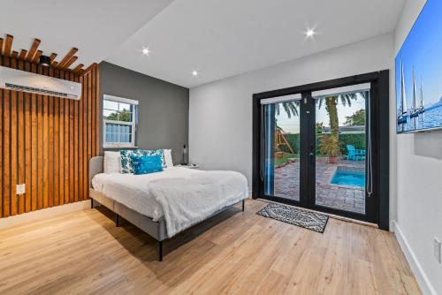 迈阿密花园Oasis with Pool Spa Games 5BR L21的一间卧室设有一张床和一个滑动玻璃门