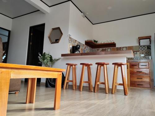 拉克鲁斯Villas Brisas de Soley的厨房配有木桌和四把凳子