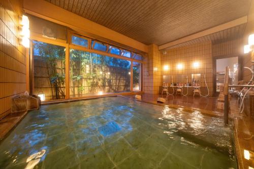 下吕市水凤园日式旅馆的一个带大窗户的房间内的游泳池
