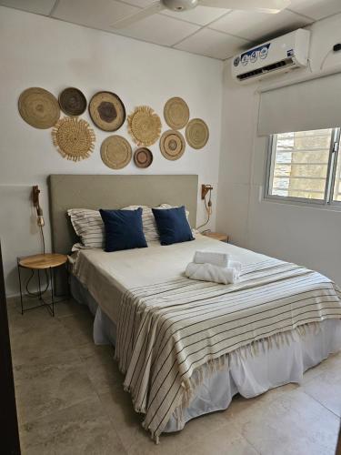 福尔摩沙Pringles Dpto Temporario 2的卧室配有一张大床,墙上挂有帽子