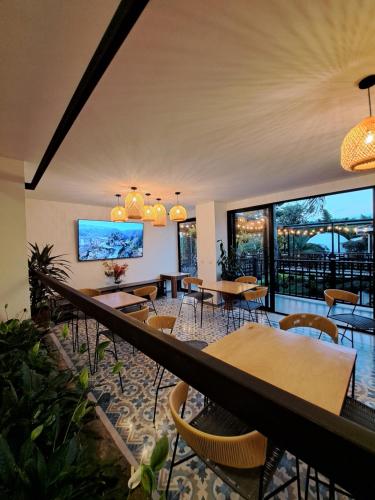 瓜塔佩Guatapé Country House Hotel的餐厅设有桌椅和大窗户。
