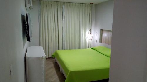 曼萨尼约Hotel Marina Puerto Dorado - Todo Incluido的一间卧室设有一张绿色的床和一个窗户。