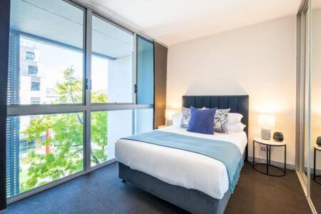 悉尼Sleek Inner-City Getaway in Prime Location的一间卧室设有一张床和一个大窗户