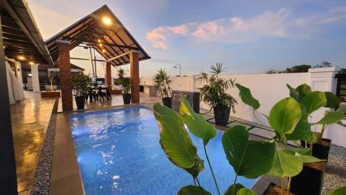 PendangCalma Villa @ Pendang的房屋中间的游泳池