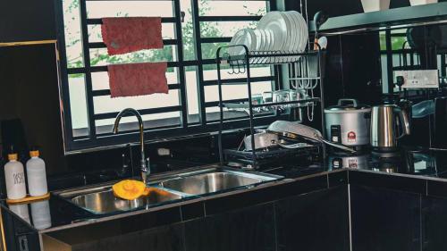 PendangCalma Villa @ Pendang的带水槽的厨房台面和窗户