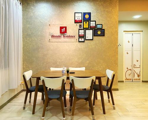 马六甲Amadel Residence 爱媄德民宿 14的一间带木桌和椅子的用餐室