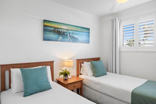 马库拉Beachside 3-Bed with Pool, BBQ, Gym & Tennis Court的一间卧室设有两张床和窗户。