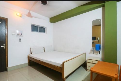 KahalgaonHotel Nilay & Banquet (Vivah Bhawan)的一间卧室配有一张床和一张桌子